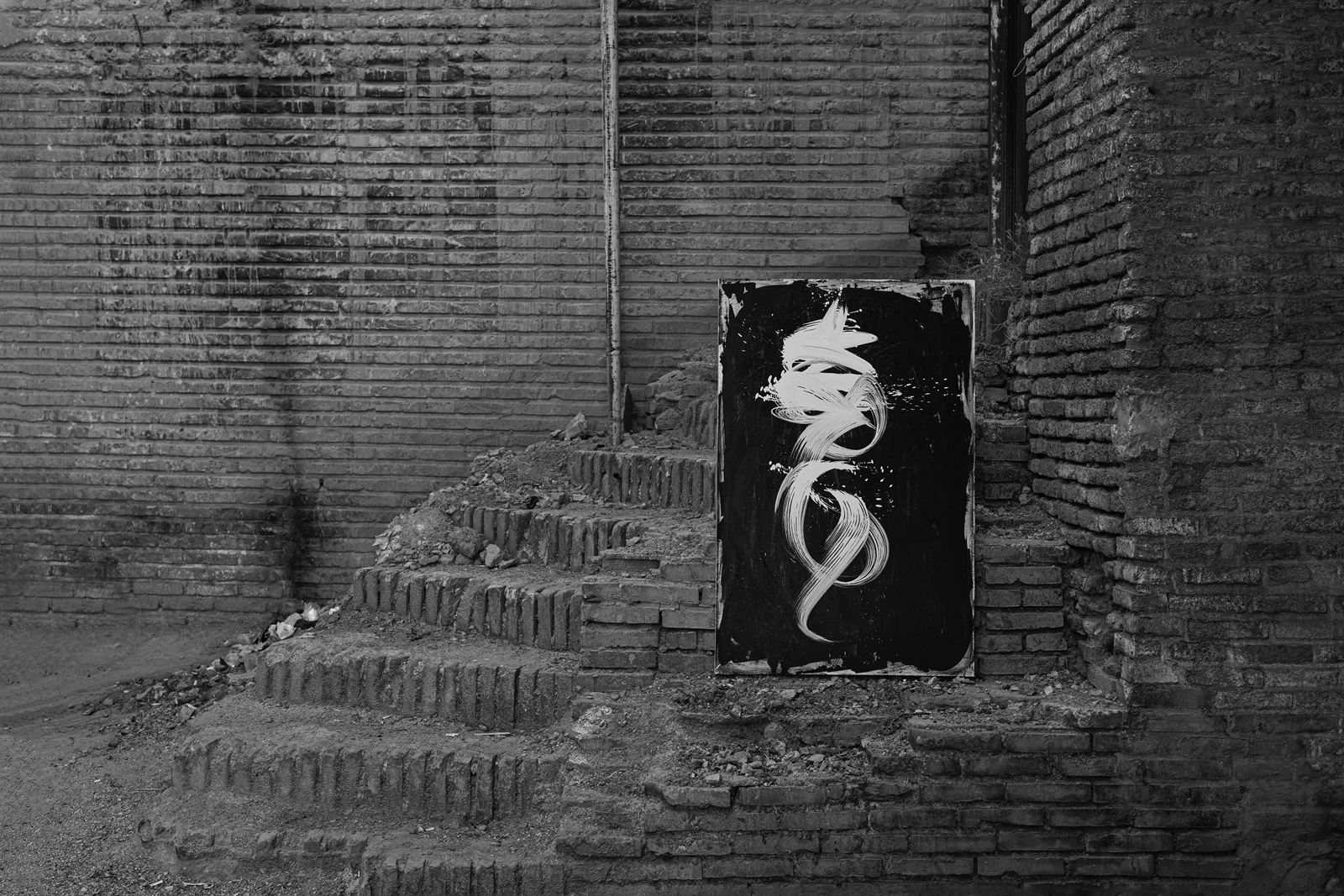 A canvas standing on the crumbling brick steps of an old house